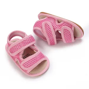 Dettaglio delle scarpine da neonato in rete rosa con suola morbida e flessibile per i primi passi