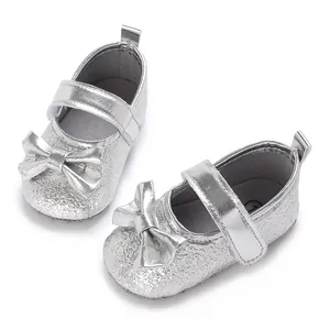 Detail von silbernen Baby-Mädchen-Prinzessin-Schuhen mit dekorativen Schleifen