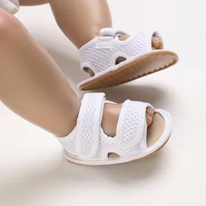 Primo piano di scarpine per neonati in rete bianca traspirante con suola morbida e velcro.