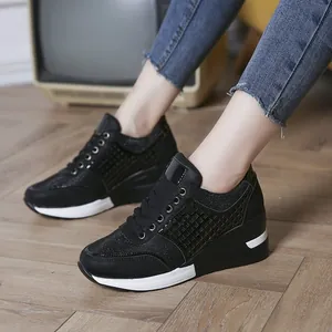 Detalle de zapatillas negras con cuña con toques de purpurina y cordones.