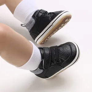 Detail view of black high-top baby walking shoes with soft soles and white cotton socks.