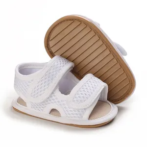Dettaglio di sandali per neonati in mesh bianco traspirante con suole morbide antiscivolo.