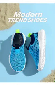 Zapatillas deportivas infantiles de malla azul transpirable sobre fondo de arena fina