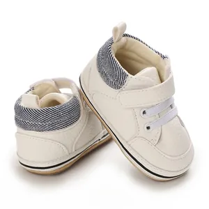 Detail of white high-top baby walking shoes with rubber soles and striped ankle collar