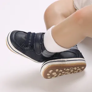 Detail of navy blue baby walking shoes featuring rubber sole with footprint patterns