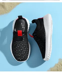 Primer plano de zapatillas transpirables de malla negra para niños con suela blanca.