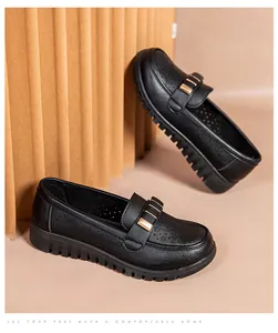 Macro detail view showing the breathable hollowed-out texture of these black leather loafers