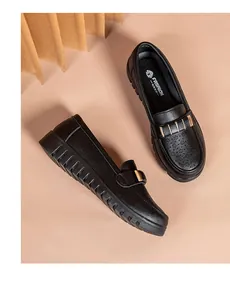 Close-up of black breathable leather loafers with gold decorative buckle and soft sole.