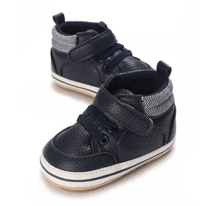 Close-up of navy blue baby high-top walking shoes with textured leather and soft soles.