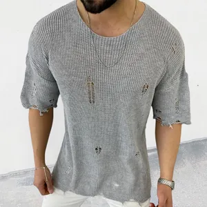 Detalle de jersey de punto gris para hombre con un efecto desgastado y manga corta