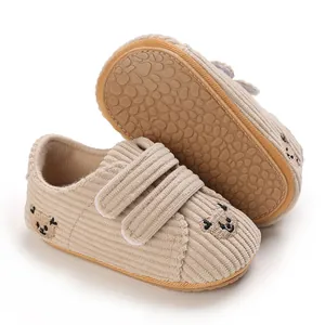 Vue détaillée de chaussures bébé en velours côtelé beige avec broderie ours et semelle