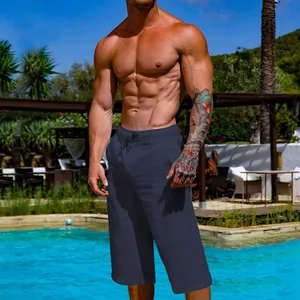 Men's breathable navy blue linen cropped pants shown in a relaxing poolside setting.
