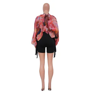 Vista posteriore di top in chiffon stampato con maniche a pipistrello e pantaloncini neri