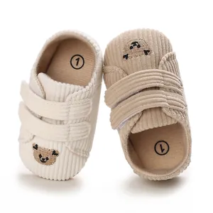 Détail de chaussures en velours pour bébé avec broderie ours et scratchs