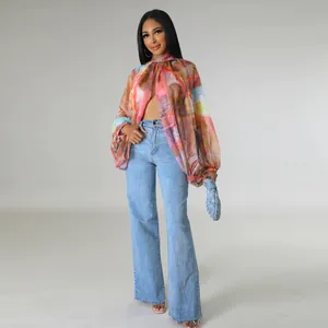 Dettaglio della blusa colorata in chiffon con stampa astratta e maniche a pipistrello