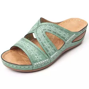 Détail de sandales à talons compensés pour femmes avec broderie florale vert menthe et semelle
