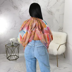 Dettaglio di una blusa in chiffon con stampa astratta e design con fiocco sul retro