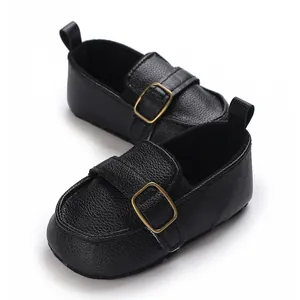 Detailed view of black faux leather baby walking shoes with elegant gold buckles