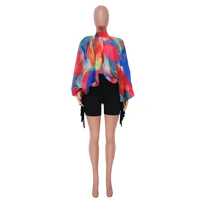 Dettaglio di una camicetta in chiffon a stampa astratta con maniche a pipistrello e shorts