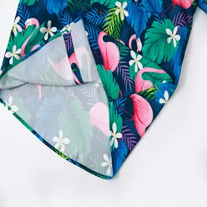 Detail view of tropical flamingo print on men's short sleeve beach shirt hemline