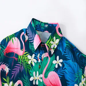 Close-up detail of a men's beach shirt featuring vibrant pink flamingo and tropical prints