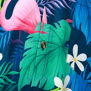 Detailed macro view of vibrant tropical flamingo and palm leaf print on men's beach shirt