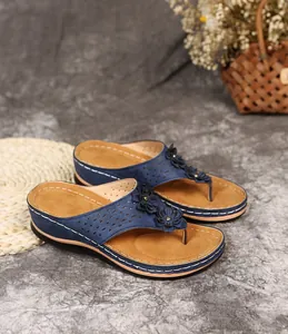 Detailansicht navyfarbener Keilsandalen mit Blumenapplikationen und Lasercuts