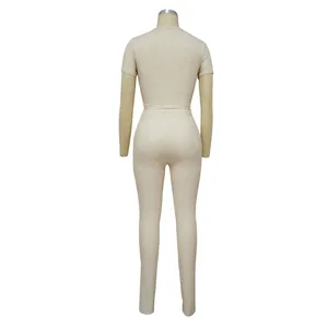 Detailed back view of a beige ribbed two-piece sports set with short sleeves and leggings