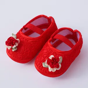 Detailansicht rote Baby-Prinzessin-Schuhe aus Spitze mit Stoffblume und Gummiband