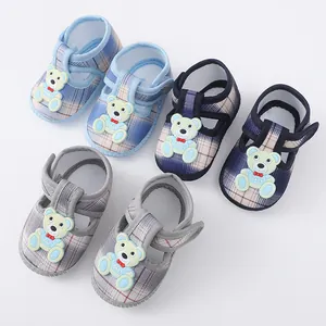 Gedetailleerde weergave van drie paar geruite babyschoenen met schattige beer motieven