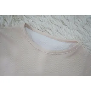 Close-up shot showing the stitching and round neckline of a beige ribbed knit sports top