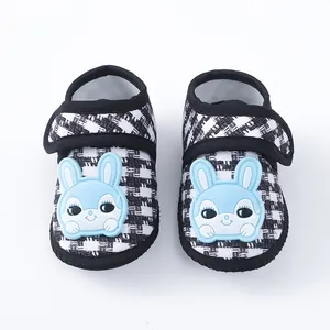 Detailweergave van zachte baby loopschoenen met pied-de-poule en blauwe konijnenpatch