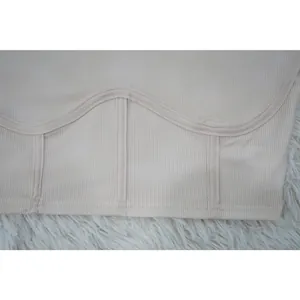 Close-up of beige ribbed fabric with curved stitching detail for women's activewear