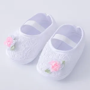 Detailansicht weißer Baby-Prinzessinenschuhe aus Spitze mit weichen Sohlen und Blume