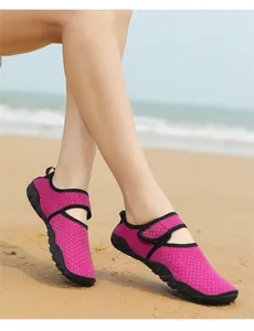 Close-up view of pink anti-slip breathable water shoes for swimming on sandy beach