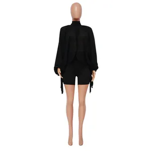 Vista dettagliata della mantella in chiffon nero con maniche a pipistrello su un manichino