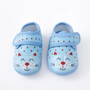 Gedetailleerd overzicht van ademende lichtblauwe babyschoentjes met stippen en kattengezicht