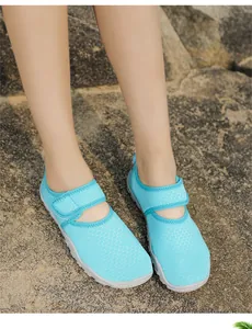 Detail of breathable cyan water shoes with mesh upper and velcro strap on rocky surface