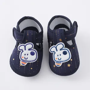 Close-up van donkerblauwe babyloopschoentjes met zachte zolen en schattige cartoonkonijntjes