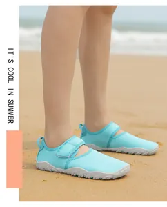 Close-up of breathable light blue water shoes with soft anti-slip soles on a sandy beach
