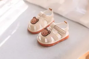 Cute beige baby sandals with brown bear decoration and soft non-slip orange soles