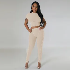 Modern two-piece beige ribbed sports set featuring a tight crop top and leggings
