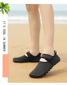 Female model wearing black breathable water shoes on a sunny sandy beach during summer.