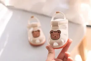 Detail view of cream baby sandals featuring cute bear motif and soft breathable sole