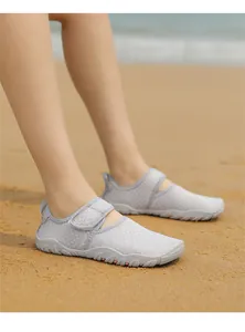 Detailed macro shot of grey breathable mesh beach water shoes on soft sand beach
