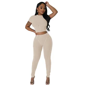 Full body view of women's beige ribbed two-piece set with crop top and leggings