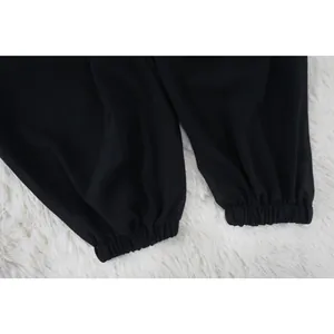 Dettaglio dei polsini elastici su una camicetta nera in chiffon con maniche a pipistrello.