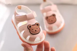 Detailed view of soft pink baby summer sandals with a cute brown bear cartoon patch design