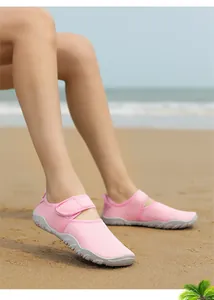Close-up of pink breathable quick-dry water shoes with non-slip soles on a sandy beach