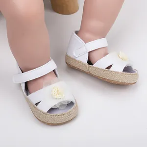 Detalle de zapatos de princesa para bebé blancos con flor de malla y suela blanda